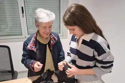 Señora enseñando a coser a una chica