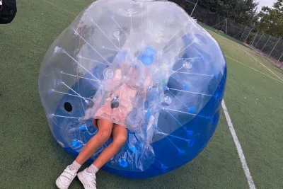 Una niña dentro de una bola hinchable.