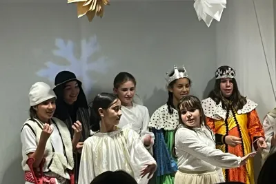 Grupo de jóvenes disfrazadas para una obra navideña en el escenario.
