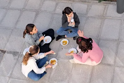 Chicas en corro comiendo ganchitos sentadas en el suelo