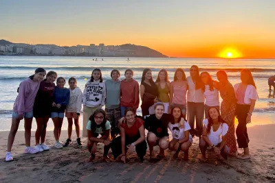 Grupo en la playa con el sol al fondo