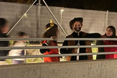 Personas disfrazadas (vaquero y rey) detrás de una barandilla exterior.