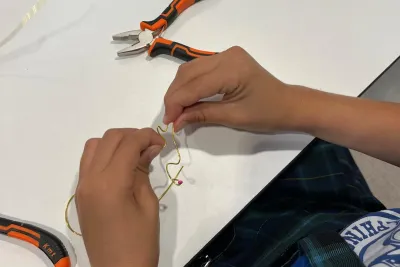 Unas manos trabajando en los pendientes con alicates.