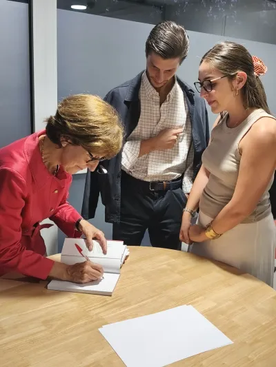 María Isabel Alvira dedicando un libro a una pareja de jóvenes al finalizar el evento