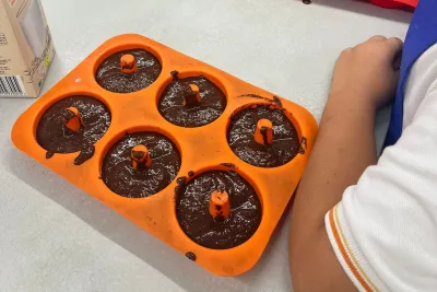 Masa de los donuts de chocolate vertida en los moldes.