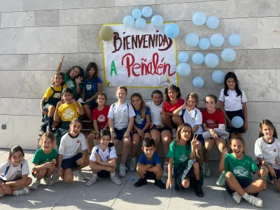 Grupo de chicas bajo el cartel de bienvenida