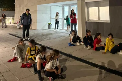 Grupo de chicas sentadas en el suelo del patio.