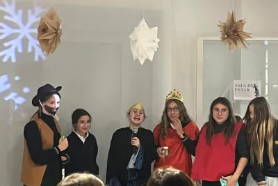 Chicas jóvenes con disfraces navideños (vaquero y reyes) en un escenario.