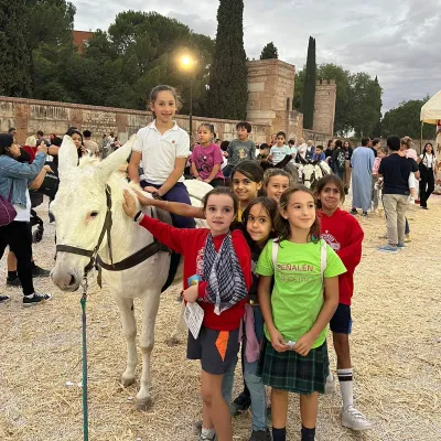 Una chica montada en burro y varias alrededor.
